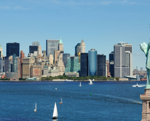 NYC skyline in daytime showing statue of liberty